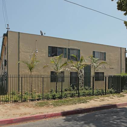 a building with a black fence and a bird on top.