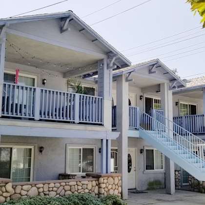a two-story house with a balcony and stairs leading to the second floor.