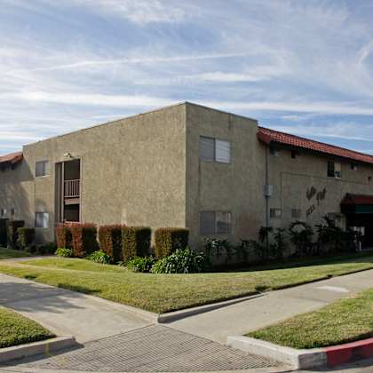 a building with a red roof and a green lawn in front.