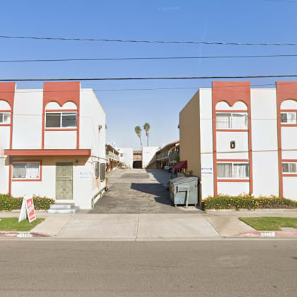 a street view of a row of red and white buildings.