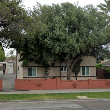 a row of houses with a red fence in front.