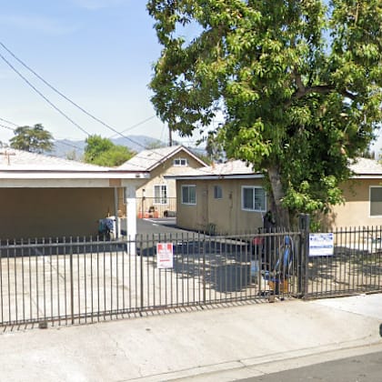a house with a black gate and a silver truck parked in front.