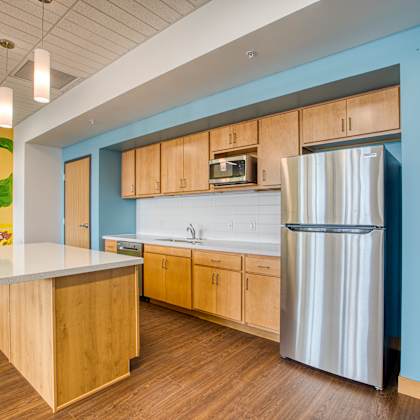 a kitchen with a wooden island and a stainless steel refrigerator.
