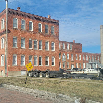 a red brick building with a yellow sign in front.
