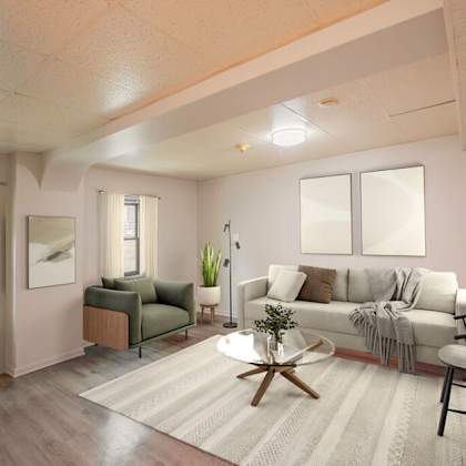 a living room with a white couch, a green armchair, and a wooden coffee table.