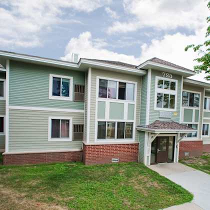 apartment building number 725 with a green lawn in front.
