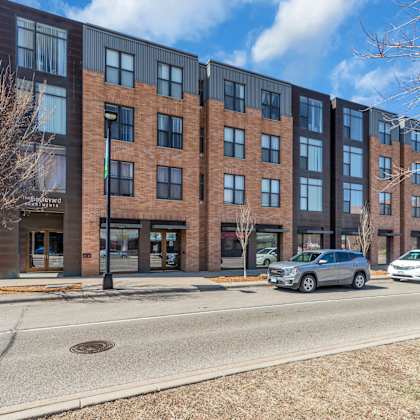 a modern brick building with a parking lot in front.
