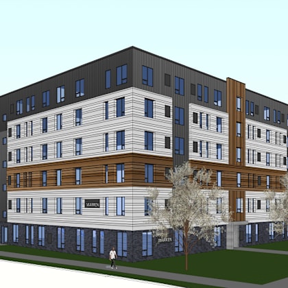 a modern multi-story apartment building with a car parked in front.