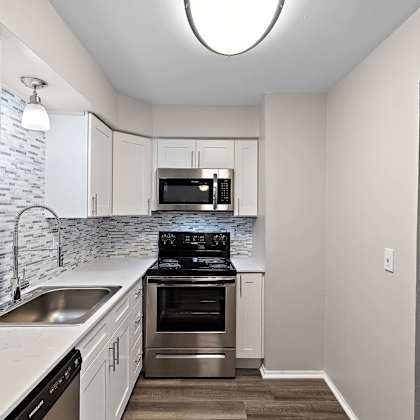 a kitchen with white cabinets and stainless steel appliances