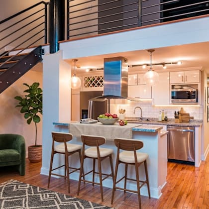 a kitchen with a bar area and a staircase.