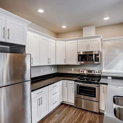a kitchen with white cabinets and stainless steel appliances