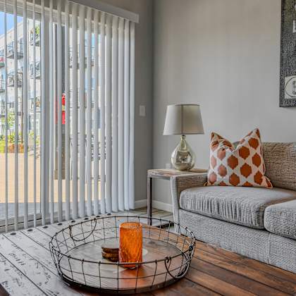 a living room with a couch and a sliding glass door to a patio