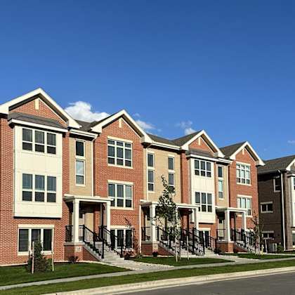 a row of brick apartment buildings on the side of a street