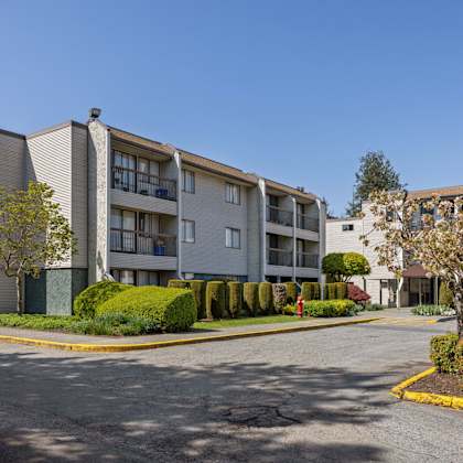 apartment complex with a parking lot in front.