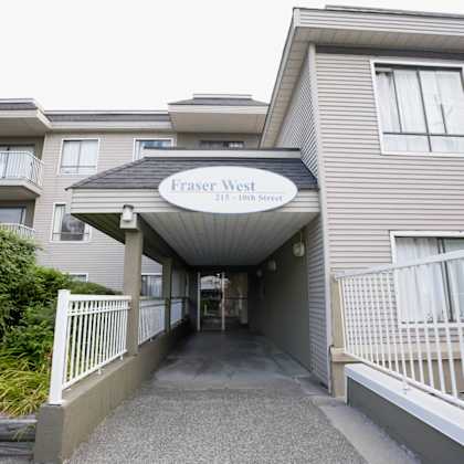 the entrance to fraser west apartments is covered by a white awning.