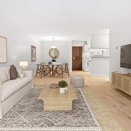 a living room with a white couch, a wooden coffee table, and a television.