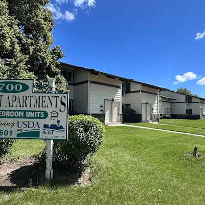 a sign for hillcrest apartments is displayed in front of a building.