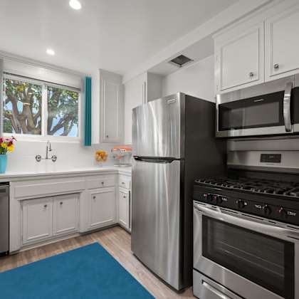 a modern kitchen with stainless steel appliances and white cabinets.