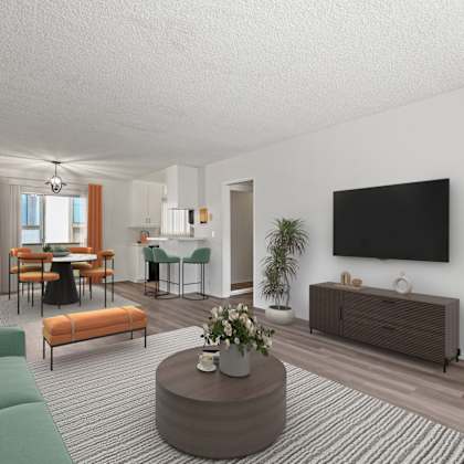 a living room with a green sofa, a wooden coffee table, and a flat-screen tv mounted on the wall.