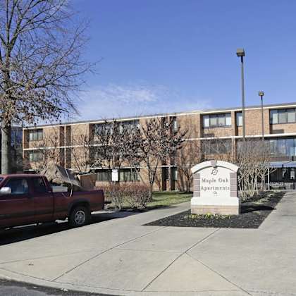 maple oaks apartments is a large apartment complex with a parking lot in front.