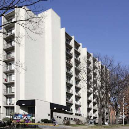 a tall white building with balconies on the side.