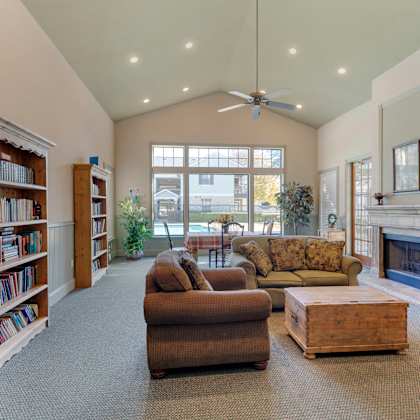 a living room with a fireplace, couches, and a bookshelf.