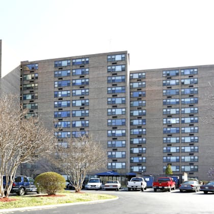 a parking lot in front of a large building with cars parked.