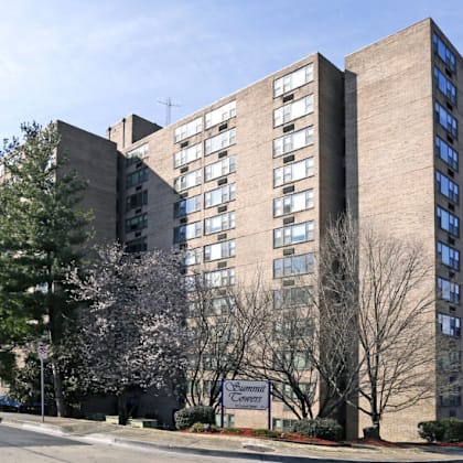 a parking lot in front of a large building with cars parked.