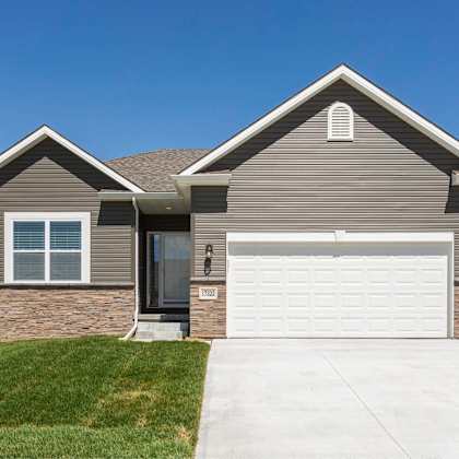 a two-story house with a garage door and a driveway.