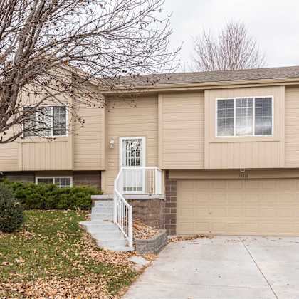 a beige house with a white door and a small porch.