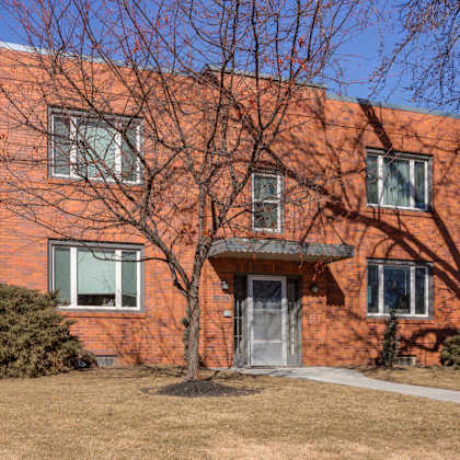 a red brick building with a tree in front.