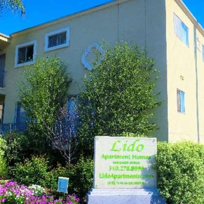 a yellow building with a sign that says lido apartment home.