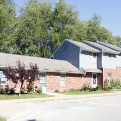 a row of houses with a car parked in front of the first one.