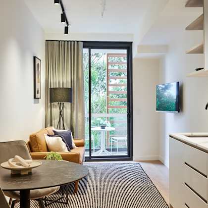 a kitchen and living room with a door to a balcony