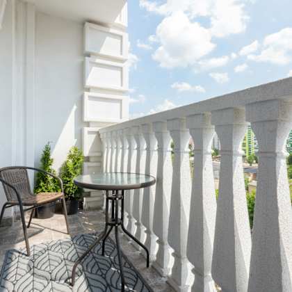 a balcony with a table and chairs overlooking a cityscape.