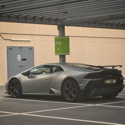 A silver Lamborghini sports car is parked in a parking lot.