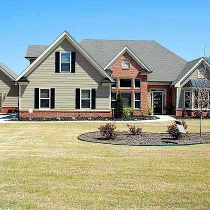 A house with a grey roof and a brown brick chimney.