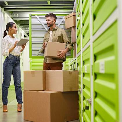 a man and a woman standing next to boxes in a warehouse
