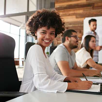 a group of people sitting at a desk with a computer