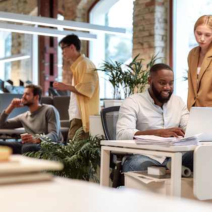 a group of people working in an office with a laptop