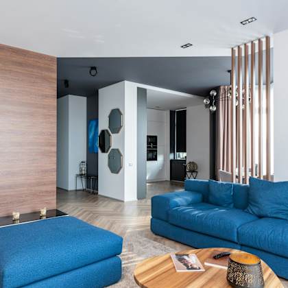 a blue couch is in the middle of a modern living room.
