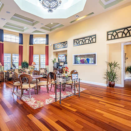 a large room with a wooden floor and a chandelier hanging from the ceiling.