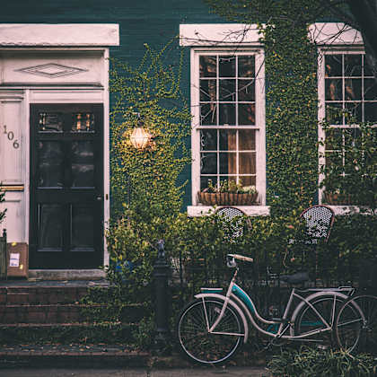 a bicycle is parked in front of a house with a door numbered 106.