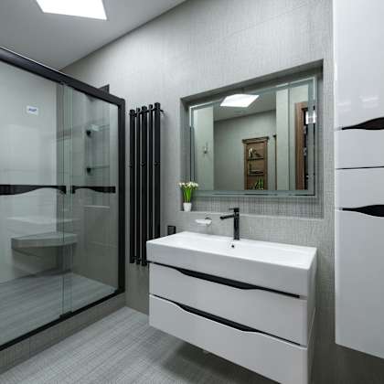 a modern bathroom with a white sink and a glass shower.