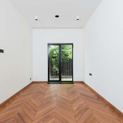 a room with a wooden floor and a glass door leading outside.