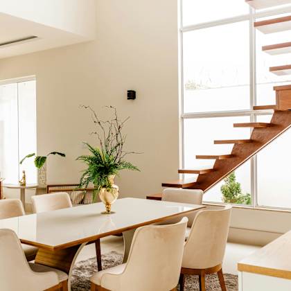 a dining room with a wooden table and white chairs.
