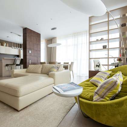a modern living room with a green chair and a white couch.