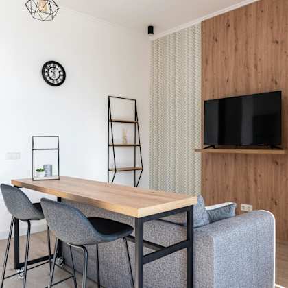 a modern dining area with a wooden table and grey chairs.