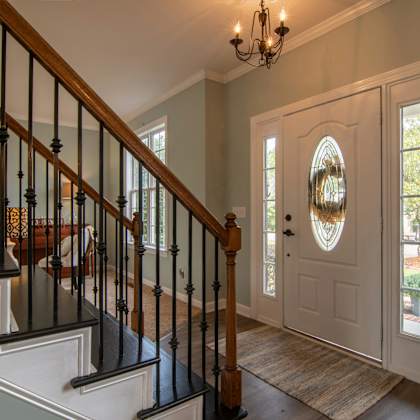 a staircase with a black railing and a light brown carpet.