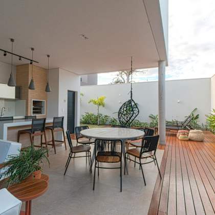a modern outdoor dining area with a wooden floor and a white table.
